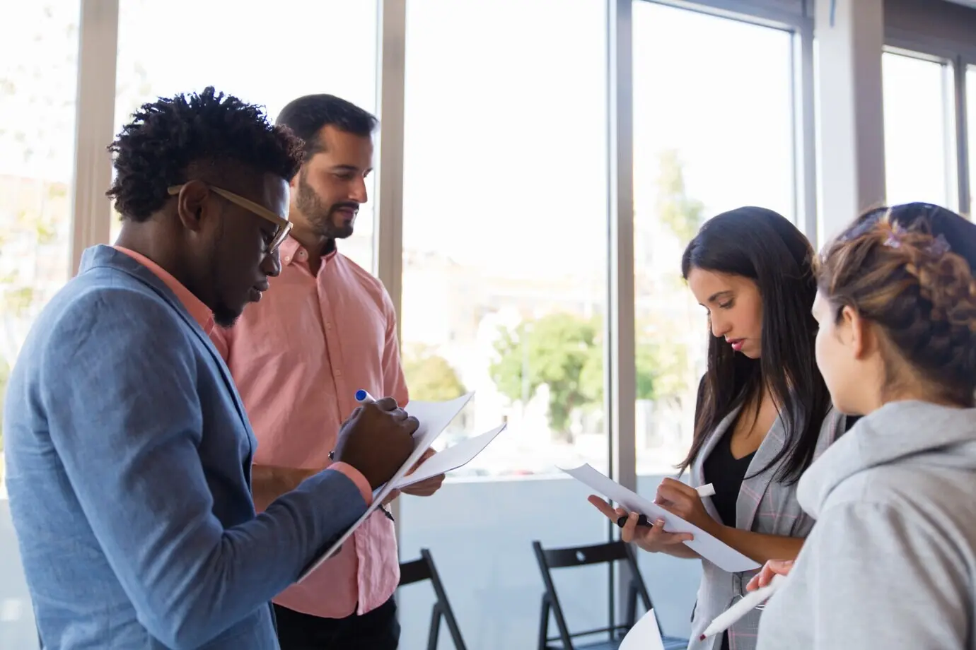 Vielfältige Kolleginnen und Kollegen machen sich Notizen, während sie Ideen austauschen.